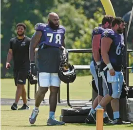  ?? KENNETH K. LAM/BALTIMORE SUN ?? Ravens right tackle Morgan Moses takes a break from the heat during practice Thursday. Moses said the cooling period was a good idea as it helps prepare the team to come out of halftime with a fast start.