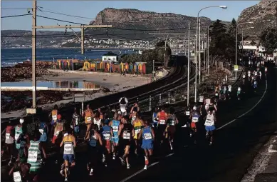  ??  ?? PLAY CLEAN: Runners in the “World’s Most Beautiful Marathon” pass the St James beach cottages in the early stages of the race.