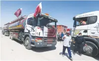  ?? (Ibraheem Abu Mustafa/Reuters) ?? A MAN GESTURES as a fuel tanker for Gaza’s sole power plant arrives while flying Qatari flags in Rafah in the southern Gaza Strip last month.