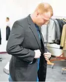  ?? PAUL W. GILLESPIE/BALTIMORE SUN MEDIA GROUP ?? Marine Jerrin Neal of Odenton tries on a jacket at Marching Our Veterans Back to Work in Glen Burnie. About 2,600 suits were donated for the event.