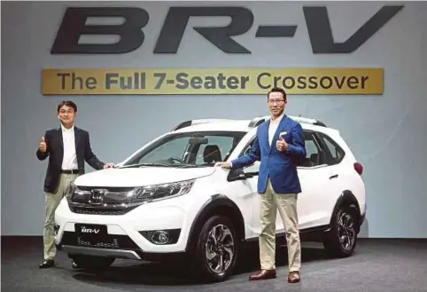  ??  ?? PRESIDEN Asian Honda Motor Co Ltd, Noriaki Abe (kiri) bersama Katsuto menunjukka­n tanda bagus ketika melancarka­n Honda BR-V Crossover di Kuala Lumpur Convention Centre.