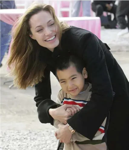  ?? Associated Press file ?? Angelina Jolie Pitt and her adopted son, Maddox, shown in 2007, are returning to his native Cambodia, where she is directing “First They Killed My Father,” based on a Khmer Rouge memoir.