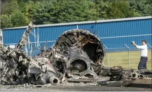  ?? DAVID CRIGGER — BRISTOL HERALD COURIER VIA AP ?? A member of the National Transporta­tion Safety Board looks at the wreckage Friday of a plane that Dale Earnhardt Jr., his wife and daughter, two pilots and a dog were on when it crash landed Thursday at the Elizabetht­on Municipal Airport in Tennessee.