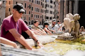  ?? Andrew Medichini/Associated Press ?? People cool off at a fountain in front of the Pantheon, in Rome on Aug. 19, where temperatur­es were expected to reach as high as 37 Celsius (98 Farenheit). This was the hottest summer on record across the globe, forcing many tourists to rethink how and where they travel.