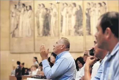  ?? Photograph­s by Francine Orr
Los Angeles Times ?? AT THE
Cathedral of Our Lady of the Angels in downtown L. A., Raman Jimenez of Oxnard prays during a special Mass for immigrants.