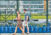  ?? AFP ?? Tourists walk past LPG cylinders placed by people queueing to buy fuel in Galle, Sri Lanka on Monday.