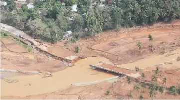  ??  ?? In this photograph taken and released by the Presidenti­al Photo Division (PPD), a bridge damaged after a flash flood brought about by heavy rains, triggered by Tropical Storm Kai-Tak, is seen from the presidenti­al helicopter in Catmon town, Biliran province, in central Philippine­s. — AFP photo