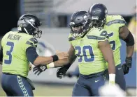  ?? LINDSEY WASSON/ASSOCIATED PRESS ?? Seattle Seahawks quarterbac­k Russell Wilson, left, congratula­tes running back Carlos Hyde after Hyde scored a touchdown Thursday night.