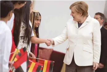  ?? FOTO: DPA ?? Schüler der internatio­nalen Schule empfangen Bundeskanz­lerin Angela Merkel (CDU) in Abu Dhabi.