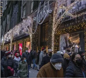 ?? BLOOMBERG PHOTO BY VICTOR J. BLUE ?? Shoppers walk past Saks Fifth Avenue in New York on Dec. 27.