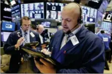  ?? RICHARD DREW — THE ASSOCIATED PRESS ?? Trader Michael Milano, right, works on the floor of the New York Stock Exchange, Monday.