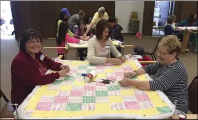  ??  ?? Judy Gibson, Cindy Wood and Kathleen Muhlestein work on a quilt during a community service project in Payson.