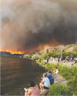  ?? DARREN HULL / AFP VIA GETTY IMAGES FILES ?? Residents watch the McDougall Creek wildfire in West Kelowna, B.C., from Kelowna on August 17, 2023. Last year's wildfire season broke records for its intensity.