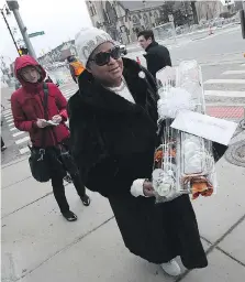  ??  ?? Lenette Williams carries flowers to Wednesday’s memorial service at the Fox Theatre for Detroit Red Wings and Tigers owner Mike Ilitch.