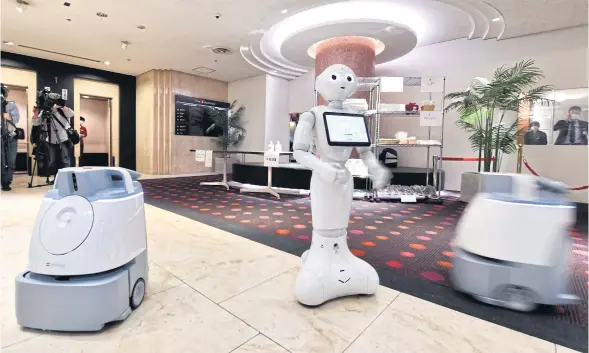  ?? AFP ?? The Softbank robo-greeter Pepper and two Whiz cleaning robots stand ready to serve in a hotel being used to accommodat­e people suffering mild symptoms of Covid-19 in Tokyo. They might become permanent fixtures once the crisis has passed and the hotel returns to welcoming regular guests.