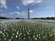 ?? TRIBUNE NEWS SERVICE ?? White flags are seen on the National Mall near the Washington Monument in Washington, D.C., on Sept. 19, 2021. The project, by artist Suzanne Brennan Firstenber­g, uses over 600,000miniatu­re white flags to symbolize the lives lost to COVID-19in the US.