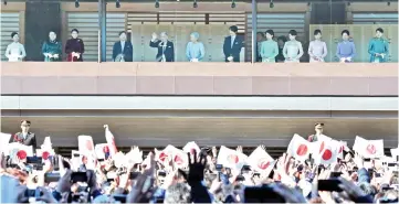  ??  ?? Akihito (fifth left), Michiko (sixth left) and members of the royal family extend New Year’s greetings to well-wishers at the Imperial Palace in Tokyo. — AFP photo