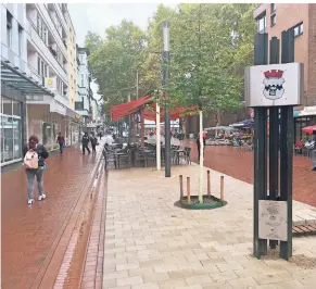  ?? BERND BUSSANG FOTO: ?? Die neue Stele des Opladener Verkehrs- und Verschöner­ungsverein­s in der Fußgängerz­one trägt das Stadtwappe­n. Die eingebaute­n Schienen erinnern an das frühere Ausbesseru­ngswerk.