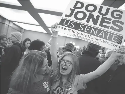  ?? JUSTIN SULLIVAN / GETTY IMAGES ?? Supporters of Democratic U.S. Senate candidate Doug Jones celebrate as Jones is declared the winner during his election night gathering in Birmingham, Ala., on Tuesday. Jones defeated Republican challenger Roy Moore to claim the seat vacated by Attorney General Jeff Sessions.