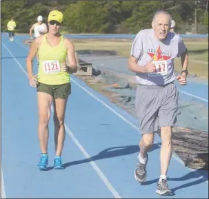  ?? The Sentinel-Record/Richard Rasmussen ?? Tamera Lewis, left, 58, of Fayettevil­le and Michael Davidson, 80, of Hot Springs compete in the Arkansas Senior Olympics 1,500-meter racewalk Friday at Jessievill­e High School. Lewis won the women’s division in 10 minutes, 18 seconds and Davidson the...