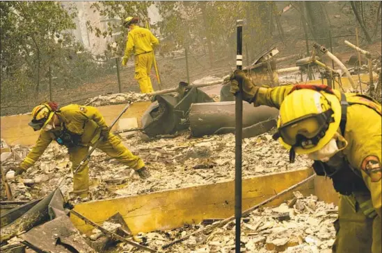  ?? Mason Trinca For The Times ?? CAL FIRE crews put out hot spots in the rubble of homes in Paradise. The death toll in the Camp fire rose to 23 on Saturday, and scores of people were still missing.