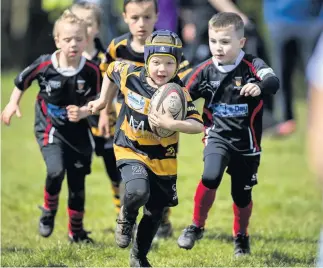  ??  ?? Helping his side to victory Tristan Greig (on the ball) scored a try as EK’s P1/P2 side triumphed