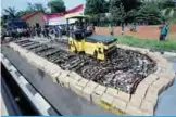  ?? —AFP ?? SOUTH TANGERANG: Indonesian police destroy thousands of bottles of illegal homemade alcohol during a public display in South Tangerang, outside Jakarta.