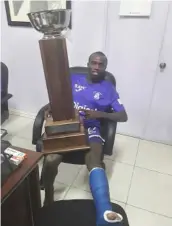  ??  ?? Ari Rodgers poses with the Digicel Manning Cup after KC defeated St George’s College 3-2 to win the title for the first time in 32 years.