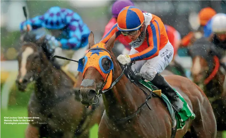  ?? GETTY IMAGES ?? Kiwi jockey Opie Bosson drives Melody Belle to the line at Flemington yesterday.