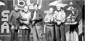  ??  ?? Abang Johari (third, left) presents a prize to one of the winners of the games and competitio­n organised recently by the BNBBC during the dinner on Friday. Also seen are Uggah (second, left), Paulus (third, right) and Asfia (second, right).