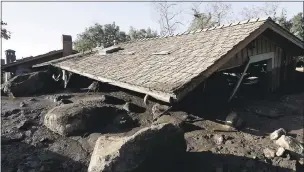  ?? MARCIO JOSE SANCHEZ — THE ASSOCIATED PRESS ?? The roof of a structure damaged from storms sits over mud and rocks in Montecito on Thursday. Hundreds of rescue workers slogged through knee-deep ooze and used long poles to probe for bodies Thursday as the search dragged on for victims of the...