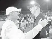  ?? JAE S. LEE/TNS ?? Southern Methodist head coach Chad Morris, left, congratula­tes UCF head coach Scott Frost after the visiting Knights’ 31-24 victory on Saturday night.