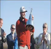  ??  ?? Marc Leishman holds the championsh­ip trophy after winningat the By Hill tournament in Orlando, Fla., Sunday.