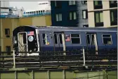  ?? PHOTOS BY FRANK FRANKLIN II — THE ASSOCIATED PRESS ?? An N trAin mo6es through the Long IslAnd City neighBorho­od in the Queens Borough of Ne York on DeC. 23.