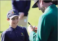  ?? David J. Phillip / Associated Press ?? Lucas Bernstein, left, waits as Masters champion Bubba Watson signs a golf ball for him during the Drive Chip & Putt national finals Sunday at Augusta National in Augusta, Ga.