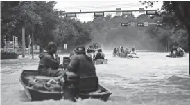  ?? GREGORY BULL/AP ?? Boats make their way down flooded streets searching for people to evacuate as floodwater­s from Tropical Storm Harvey rise Tuesday in Kingwood, Texas.