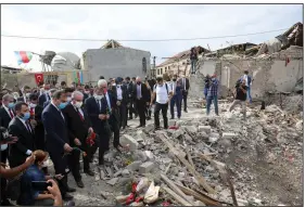  ?? (AP/Aziz Karimov) ?? Mustafa Sentop (third from left in first row), speaker of Turkey’s Parliament, views the site where houses in a residentia­l area were hit by Armenian rocket fire in Ganja, Azerbaijan’s second-largest city. The fighting over the separatist area of Naborno-Karabakh has raised concerns of a wider conflict involving Turkey and Russia. More photos at arkansason­line.com/1021confli­ct/.