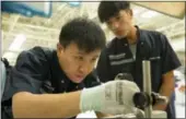  ?? MARK SCHIEFELBE­IN — THE ASSOCIATED PRESS ?? A Chinese trainee worker practices an inspection measuremen­t at an Audi transmissi­on plant in northern China’s Tianjin Municipali­ty on Monday.