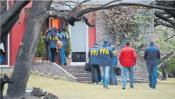  ??  ?? El Calafate. Integrante­s de la Policía Federal ingresan en septiembre de 2018 a la casa de los Kirchner por orden del juez Claudio Bonadio.