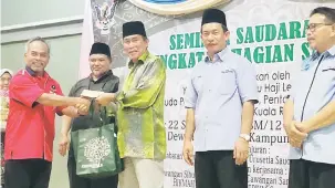  ??  ?? TAHNIAH: Len menyampaik­an penghargaa­n kepada peserta Seminar Saudara Kita Bahagian Sarikei kelmarin.