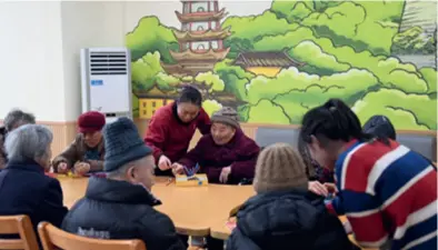  ?? ?? Nursing staff (standing) play puzzle games with disabled elderly persons at the Jinshengyi Nursing Home on January 22