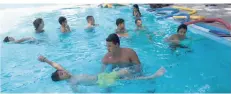  ?? FOTO. TL ?? Der Sportstude­nt Paul Huber gibt auch mal Hilfestell­ung, während er mit den Kindern das sichere Schwimmen im Wasser übt.