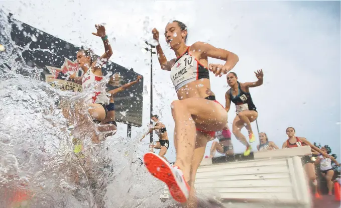  ??  ?? Geneviève Lalonde (10) franchit l’obstacle d’eau au 3000m steeplecha­se aux Championna­ts canadiens d’athlétisme, jeudi à Ottawa. - La Presse canadienne: Frank Gunn