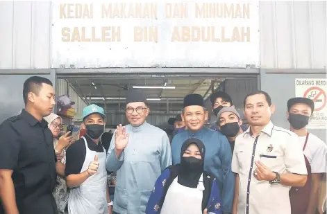  ?? photo — Bernama ?? Anwar (fourth left) and Aminuddin (fourth right) with the staff after having lunch at Warung Pak Salleh in Port Dickson yesterday.