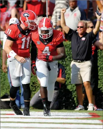  ??  ?? GeRrgia TuarWerbac­k AarRn 0urray (11) cRngraWula­Wes GeRrgia running back .eiWK 0arsKall afWer 0arsKall’s touchdown catch in the first half Saturday. The score was tied at halftime, but Georgia wound up winning.