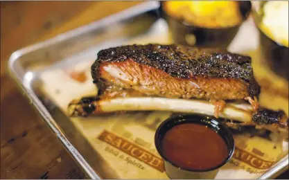  ?? STAFF FILE PHOTO ?? Smoked Dinosaur Beef Rib is one of the offerings at Sauced BBQ and Spirits in San Jose, Livermore and Walnut Creek. Barbecue restaurant­s around the Bay Area offer meals to go for Labor Day weekend, and some have outdoor dining.