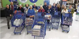  ?? BILL LACKEY / STAFF ?? Springfiel­d Police and volunteers pose with food for Operation Thanksgivi­ng before distributi­ng it to 10 area families, Tuesday.