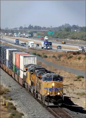  ?? AP/ RICH PEDRONCELL­I ?? A freight train rolls south along U. S. 99 near Livingston, Calif., in this fi le photo. A rule proposed this week could force U. S. railroads to share their tracks with competitor­s under certain conditions.