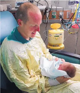  ?? COURTESY OF REBECCA HOLETS ?? Albuquerqu­e police officer Ryan Holets hold his daughter Hope after she was born five weeks early. Ryan and his wife Rebecca adopted the baby from a couple struggling with addiction.