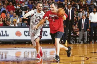  ?? Michael Ciaglo / Houston Chronicle ?? Sen. Ted Cruz dribbles past talk-show host Jimmy Kimmel during Saturday’s Blobfish Basketball Classic at Texas Southern University’s Health &amp; Physical Education Arena.